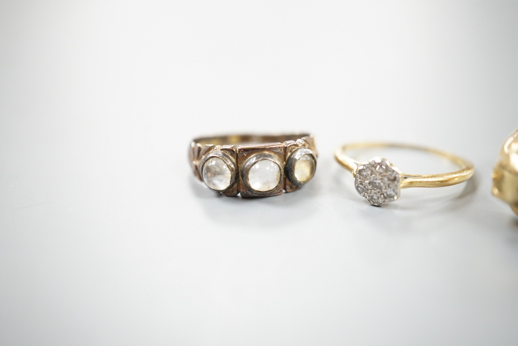 A modern 9ct gold and gem set twin leopards head ring, size S, gross 5.6 grams, a late Victorian 15ct gold and three stone moonstone ring, size M/N (shank cut), gross 3.3 grams and an 18ct and diamond cluster ring, size